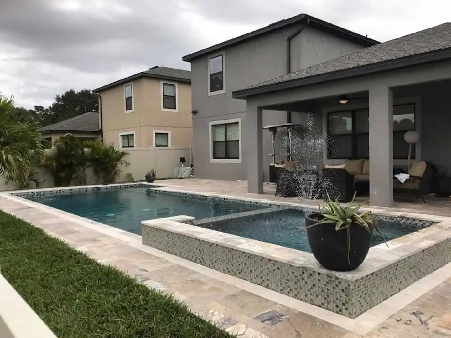 Modern backyard with a swimming pool, spa, patio, and contemporary house exterior