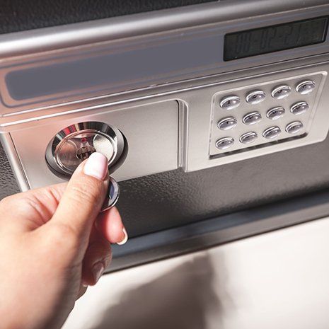 Woman using key to open safe