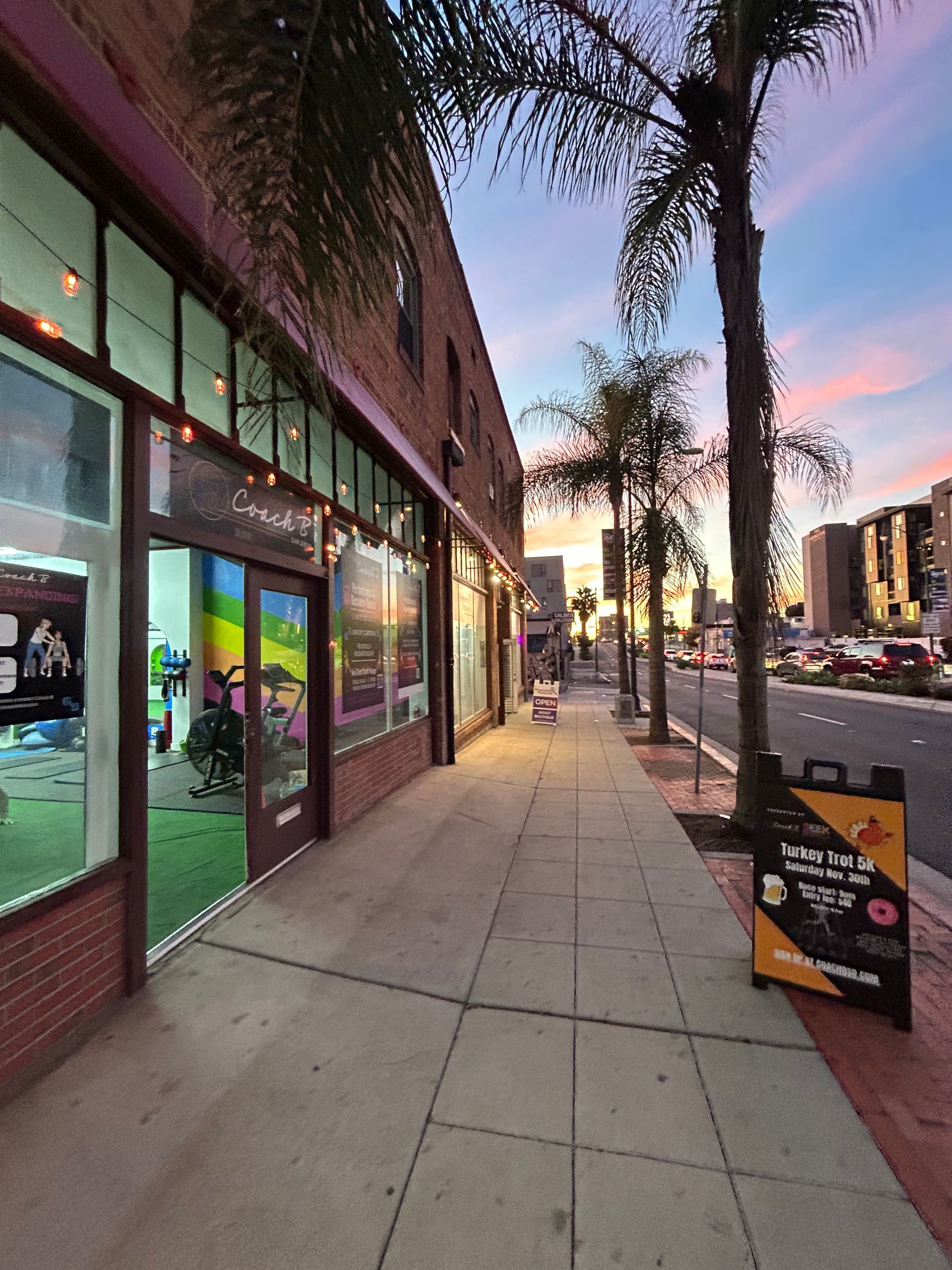 A sidewalk in front of a building with a sign that says ' sunny side up ' on it
