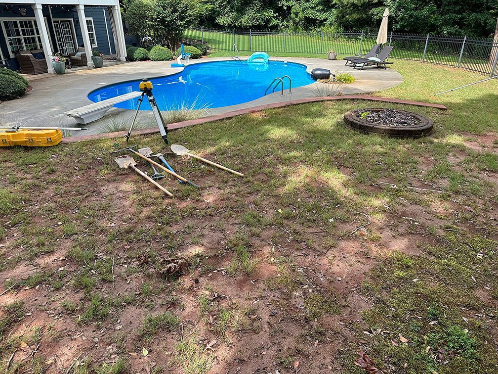 A backyard with a swimming pool and a fire pit.