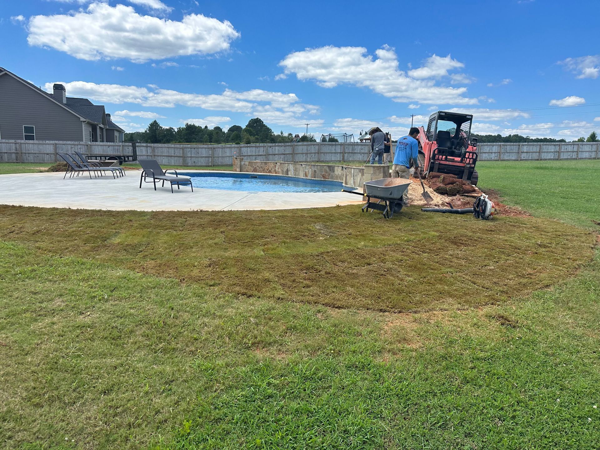 A swimming pool is being built in the backyard of a house.