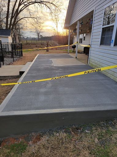 A concrete walkway is being built in front of a house.