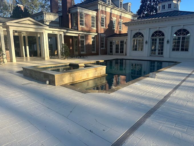 A large house with a large swimming pool in front of it.