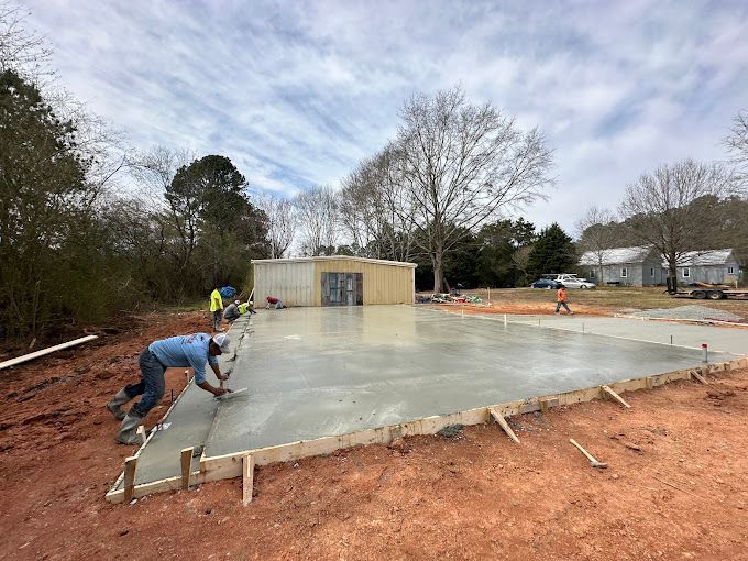 A group of construction workers are working on a concrete floor.