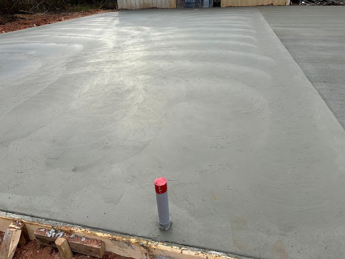 A concrete driveway with a pipe in the middle of it.