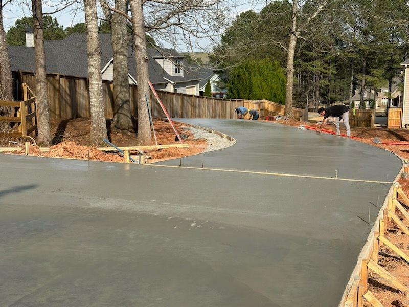 A concrete driveway is being built in front of a house.