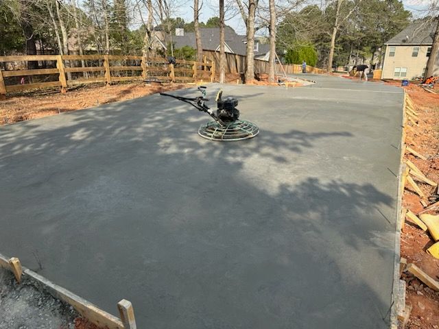 A concrete finisher is being used to finish a concrete driveway.