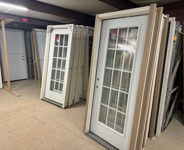 A bunch of white doors are stacked on top of each other