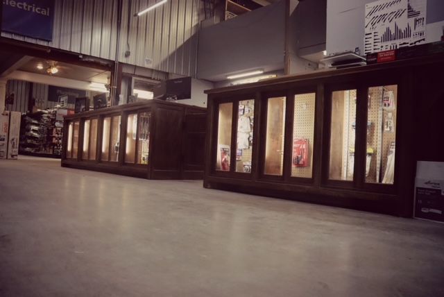 A large wooden counter in a store with a lot of windows