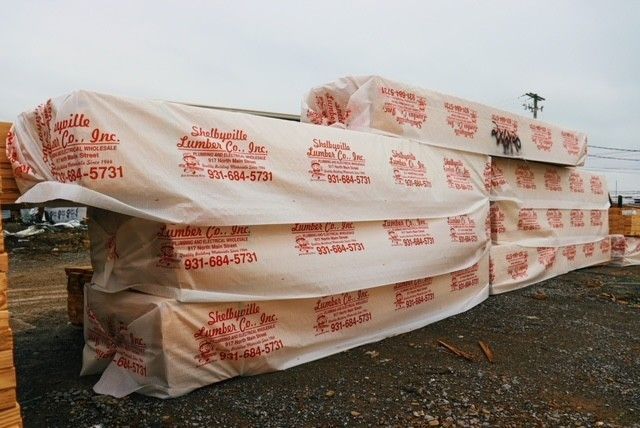 A warehouse filled with lots of wooden boards stacked on top of each other