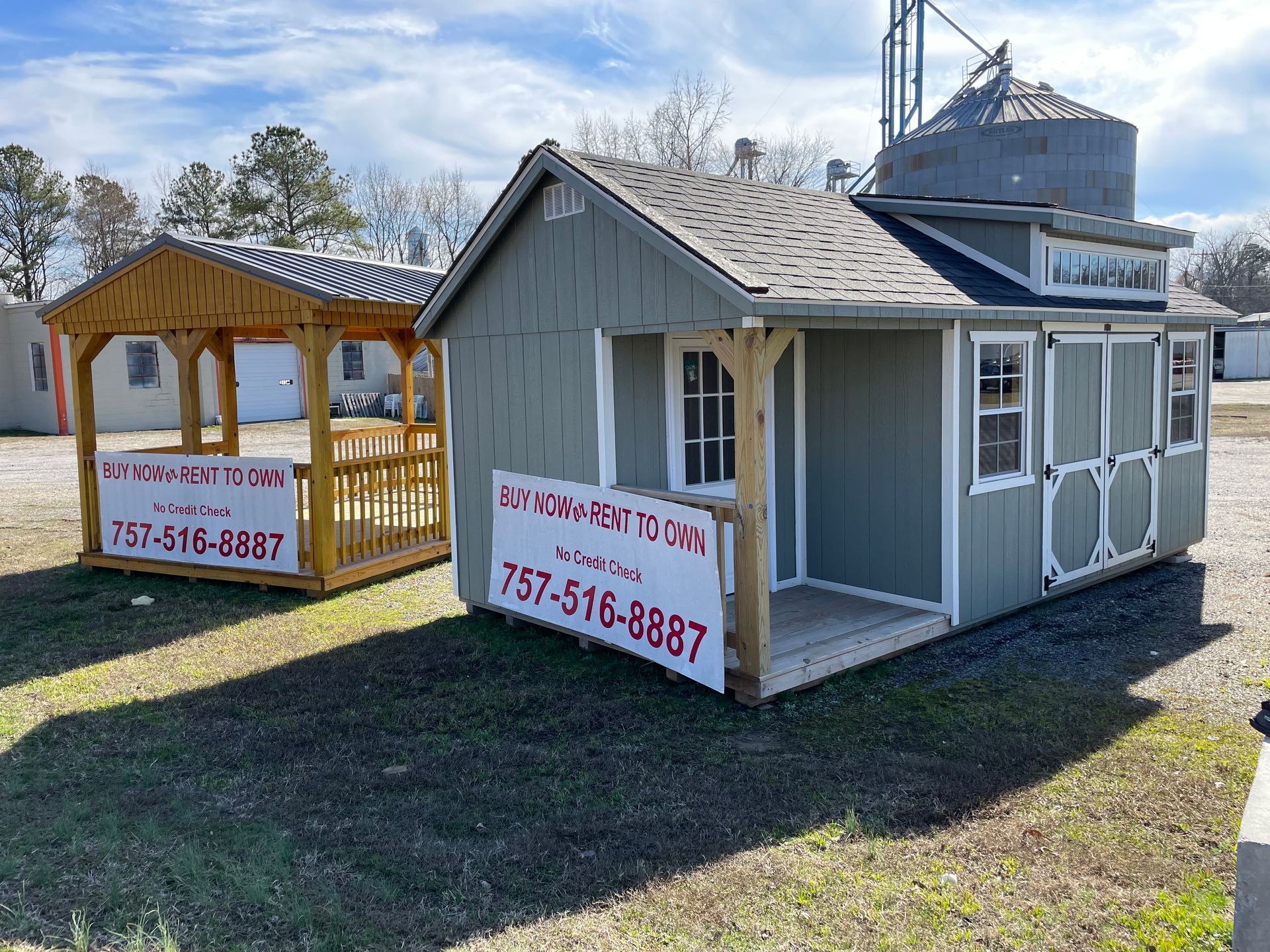 A gray shed and a wooden gazebo sitting on a gravel lot, both displaying rental signs with the phone number 757-516-8887.