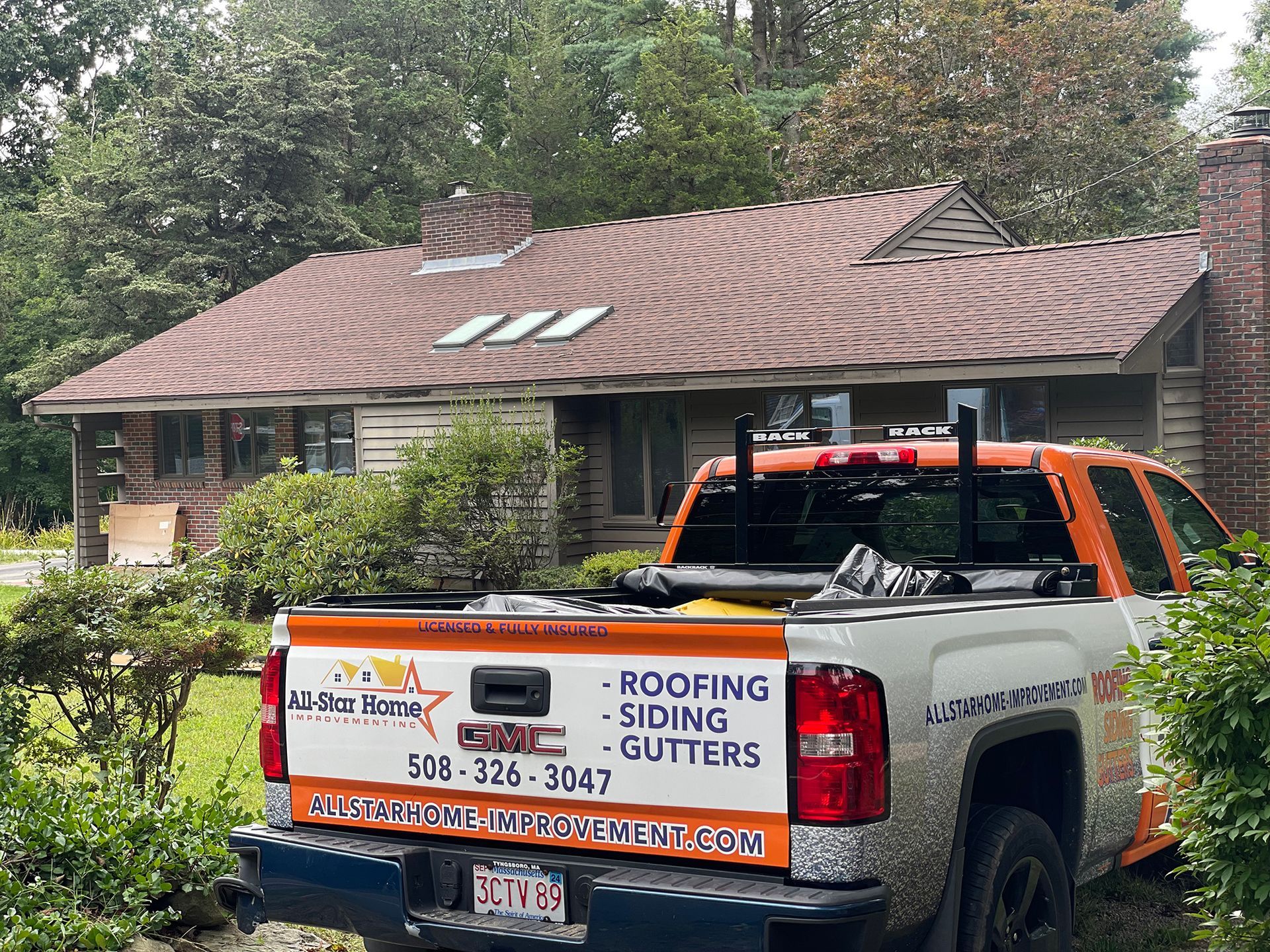 All-Star Home Improvement Inc truck in front of a newly installed residential roof