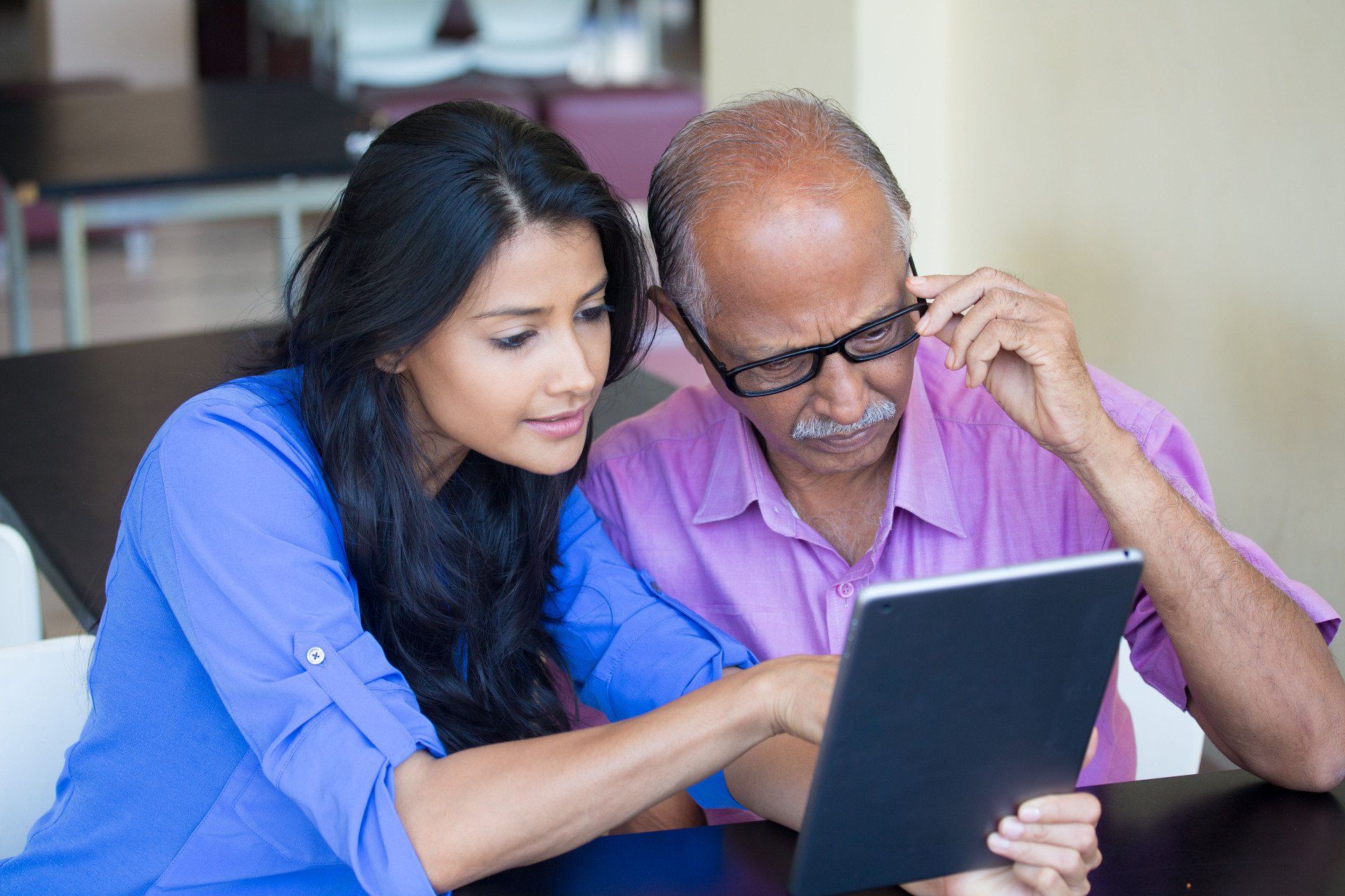 Woman helping man read 