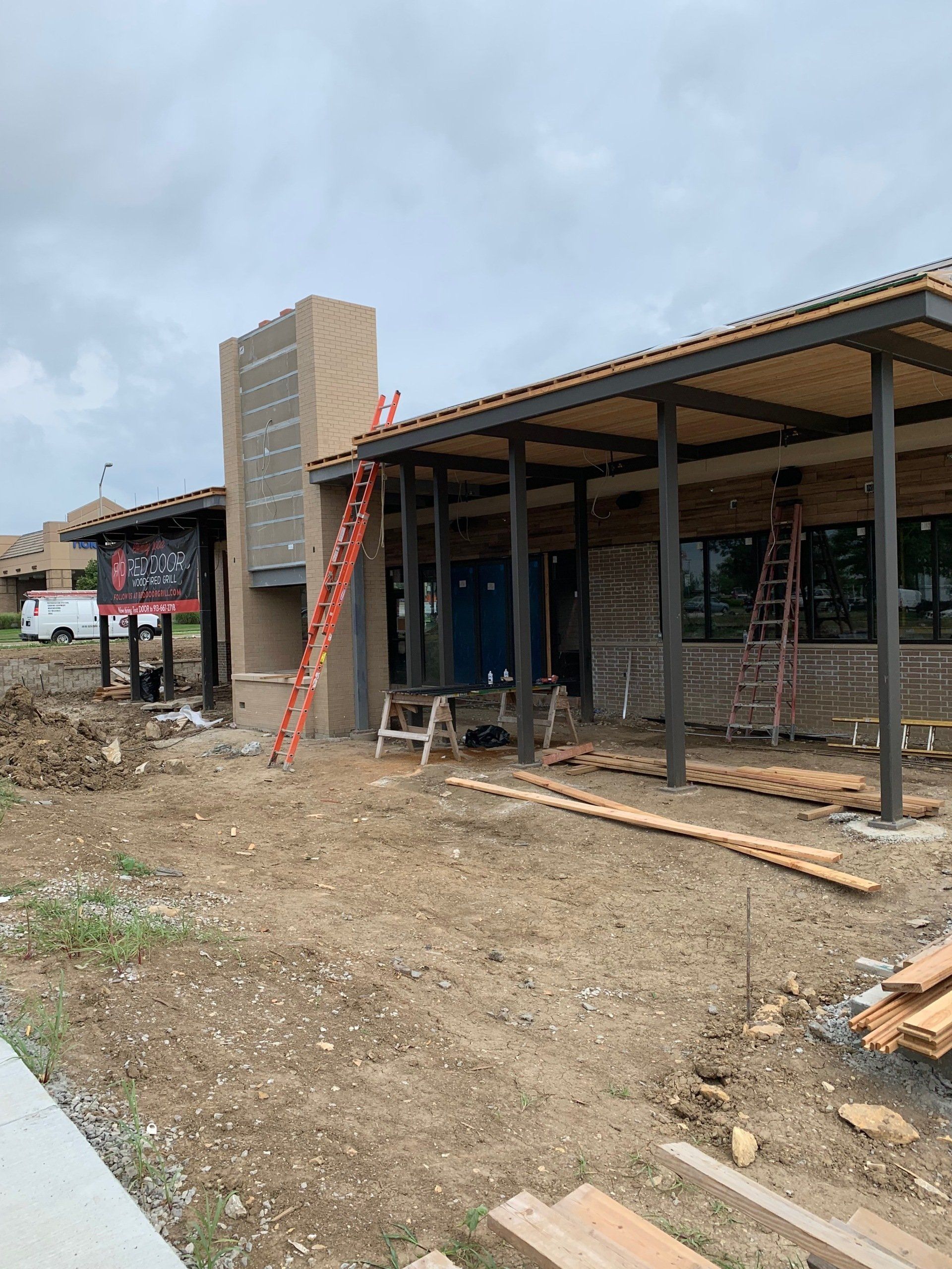 A building under construction with a ladder in front of it.