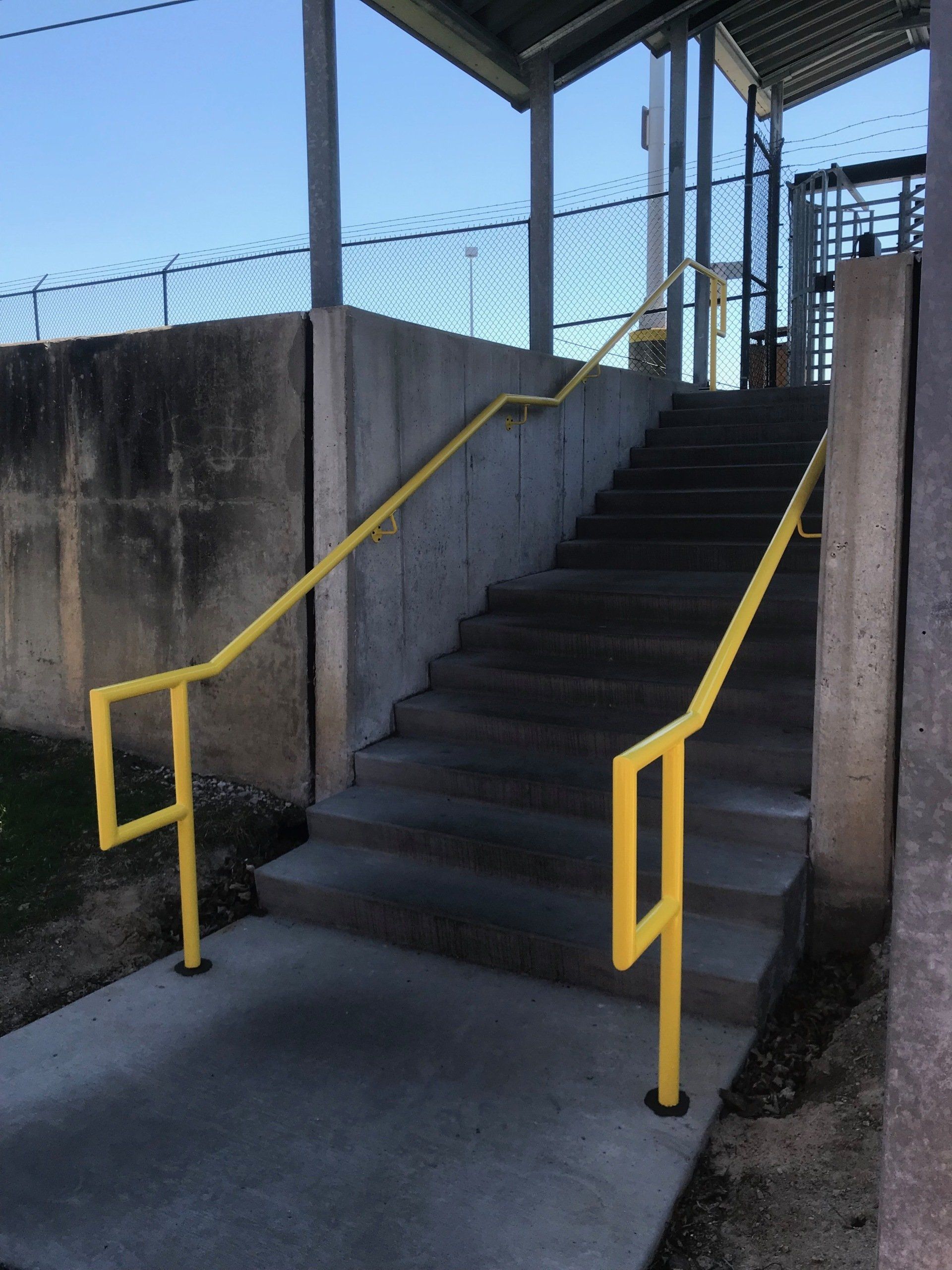 A set of stairs with a yellow railing