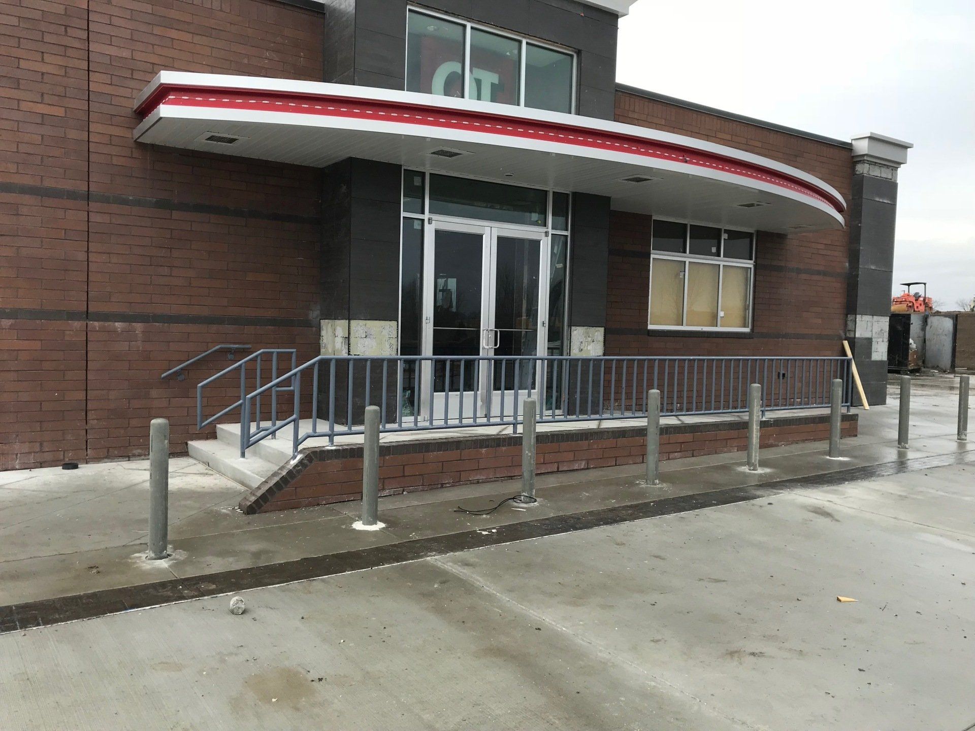 A brick building with a red and white awning over the entrance.