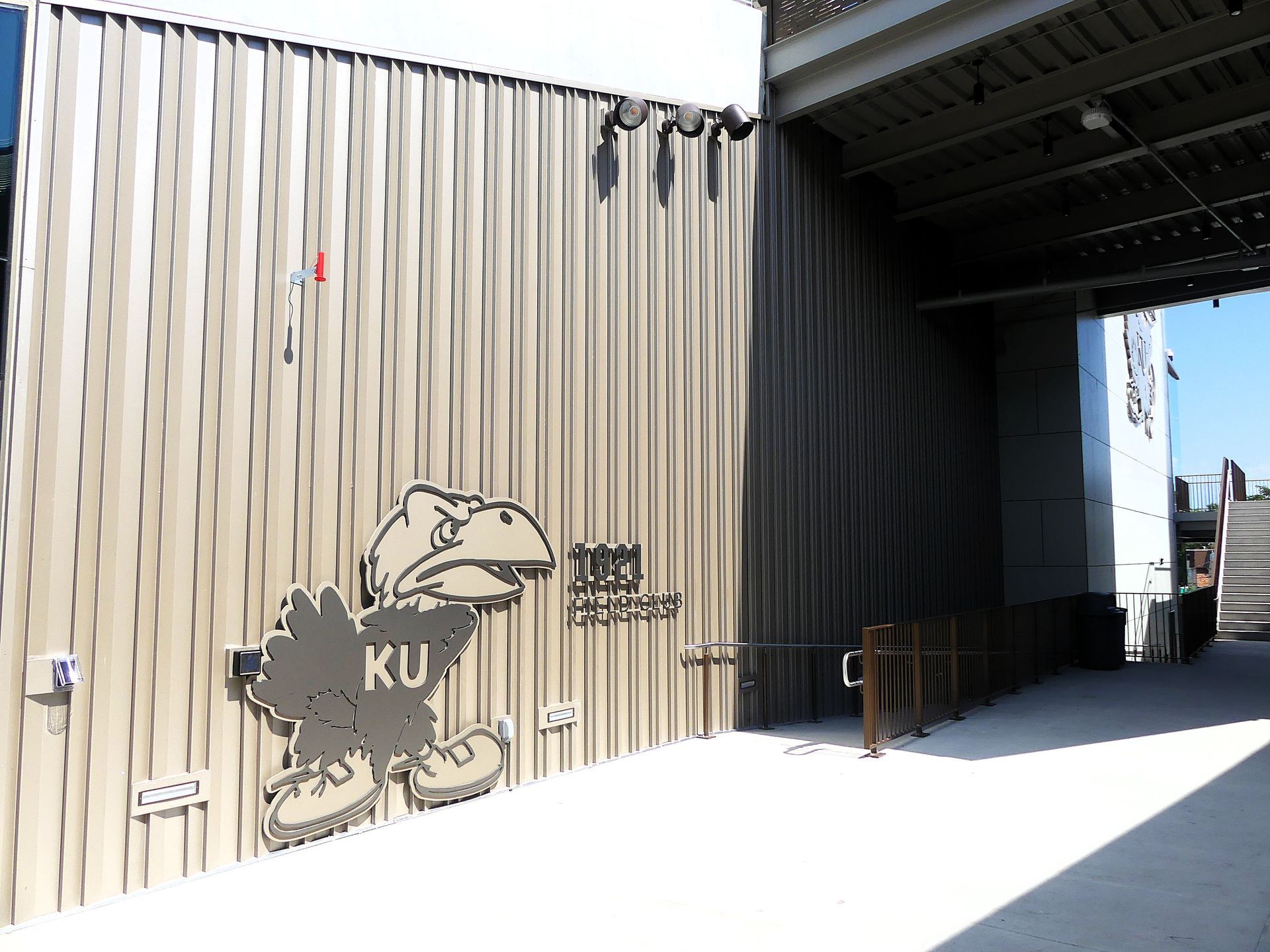 Wall with KU Jayhawk graphic and a ramp, under an overhang.