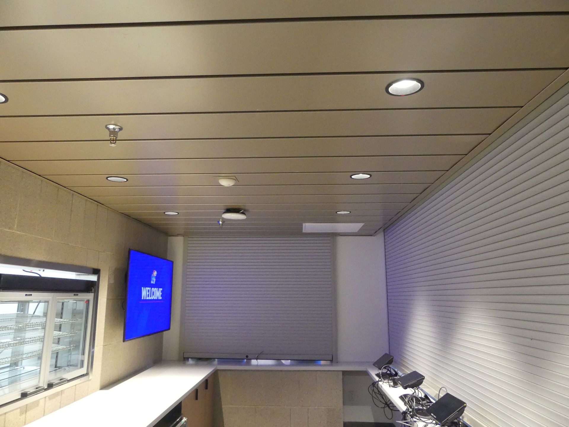 Interior of a room with a blue TV, white walls, and a light-colored ceiling.