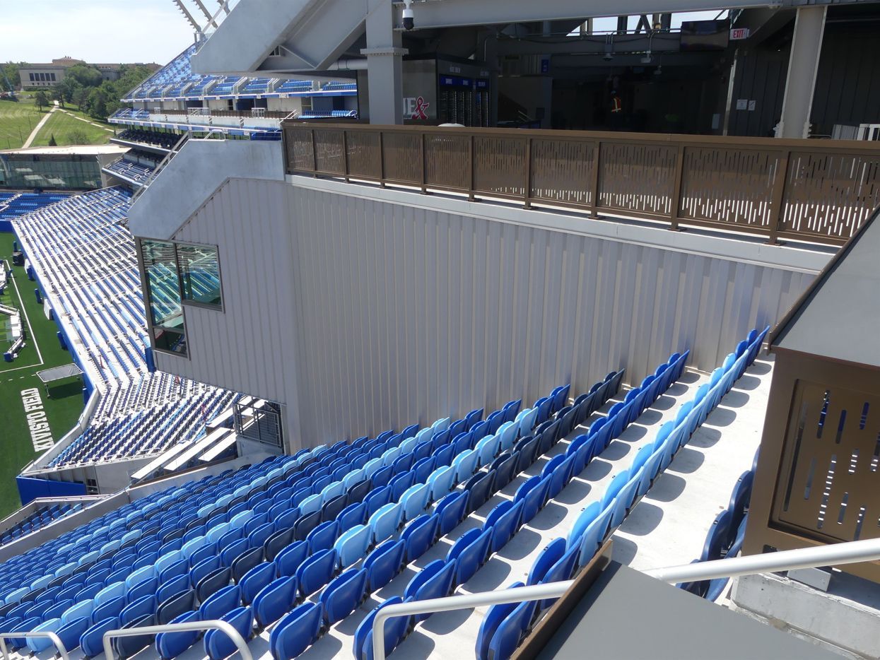 Stadium seating with rows of blue seats.