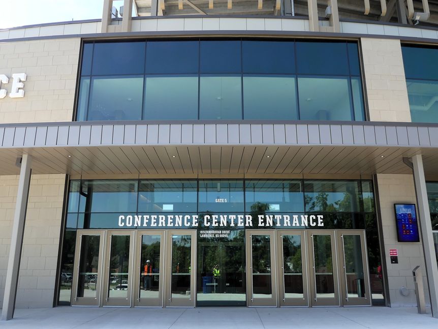 Conference Center Entrance with glass doors, sign, and beige exterior.