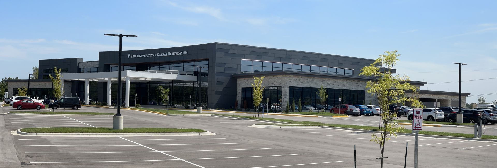 A large building with a lot of cars parked in front of it.
