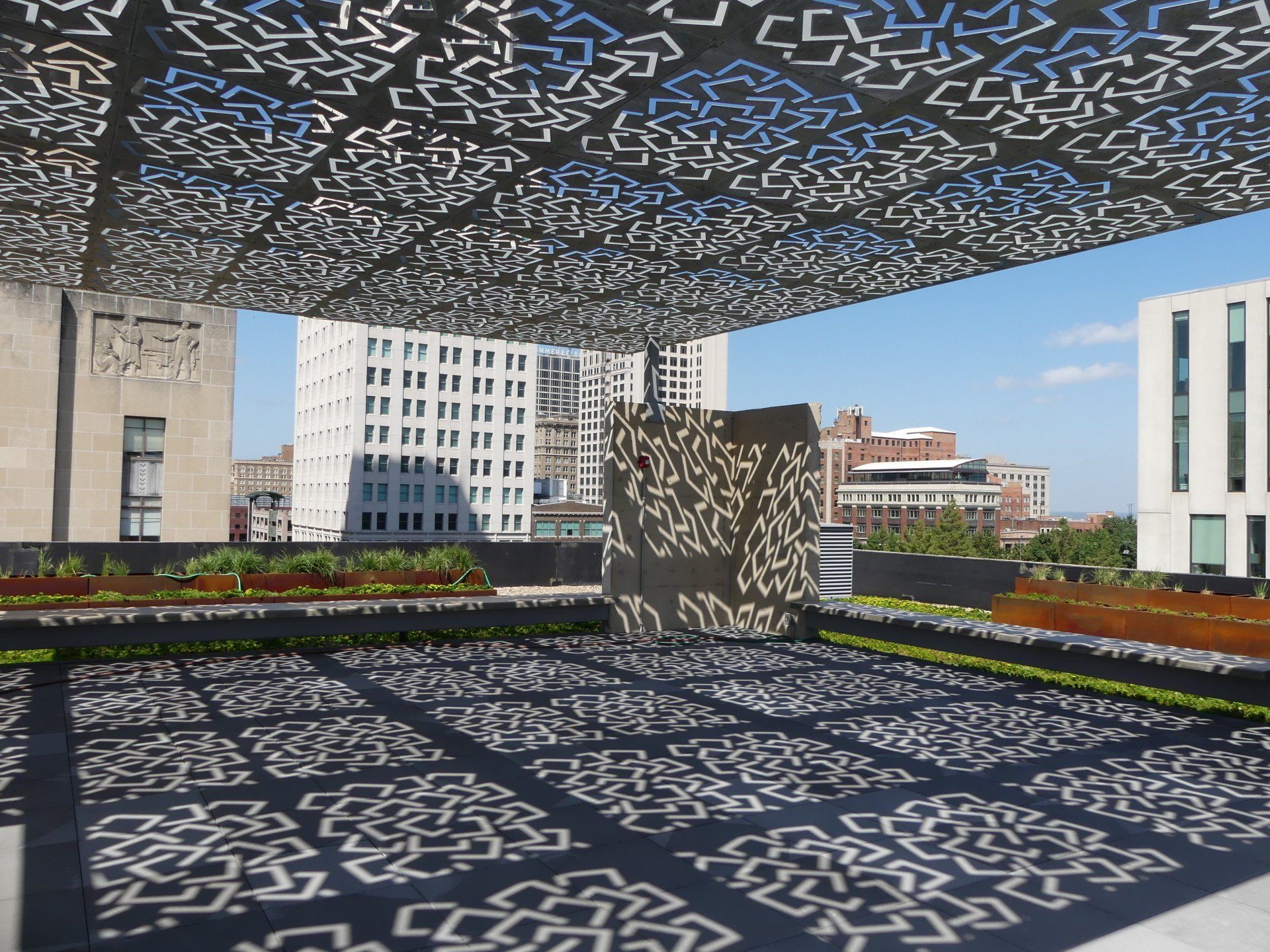 A rooftop with a canopy and a statue in the background