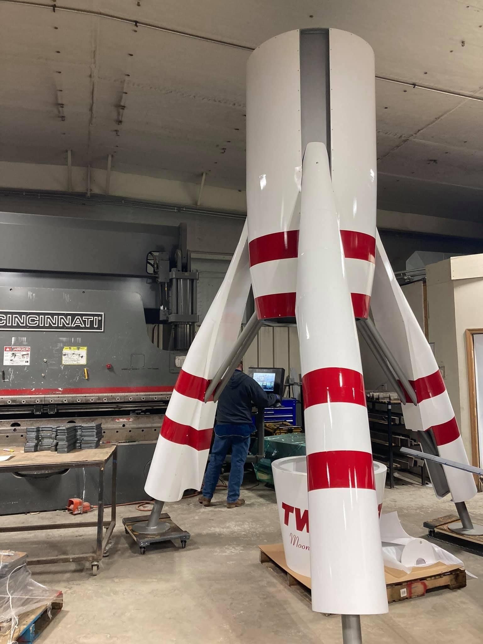 A man is working on a rocket in a factory