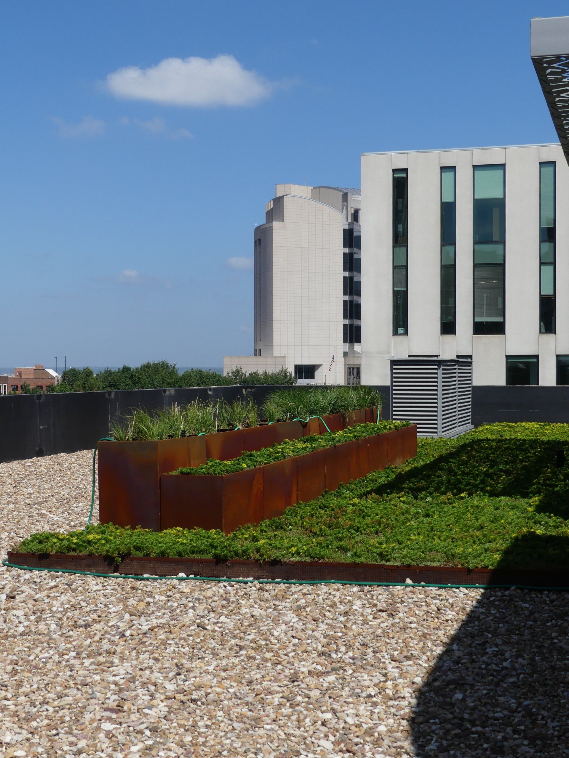 A large building with a lot of windows is behind a row of planters