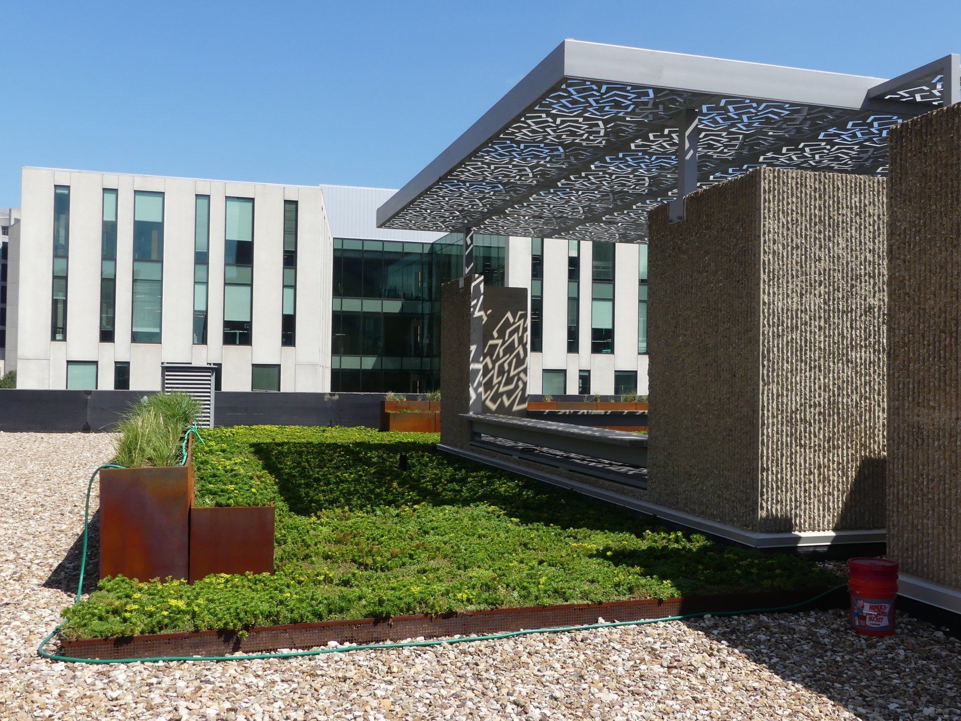 A building with a lot of windows and a lot of plants in front of it
