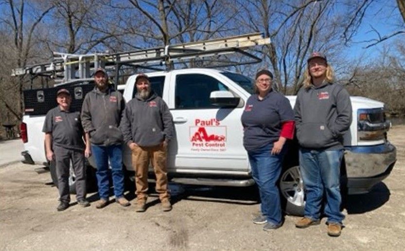 A group of people standing in front of a truck.