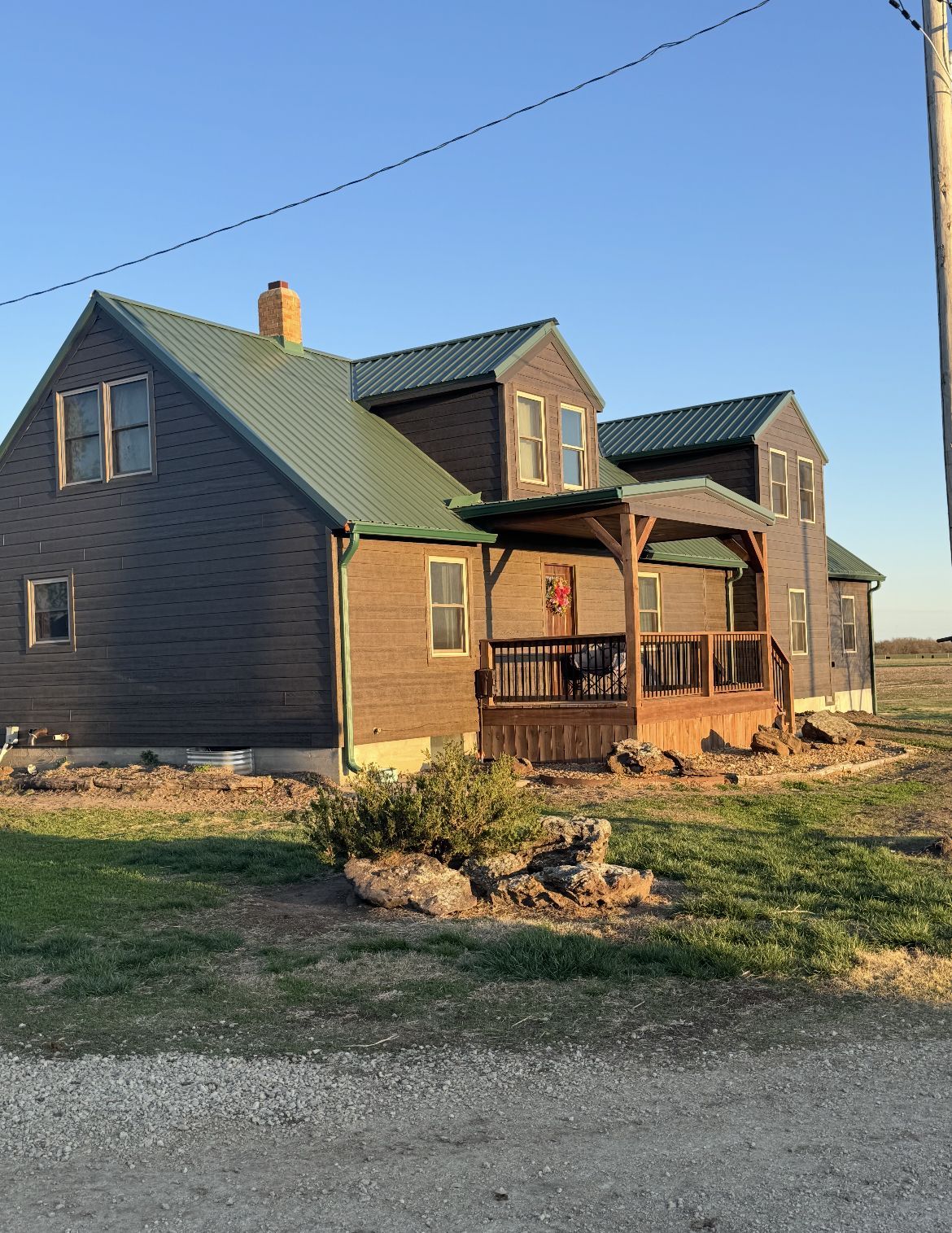 A large wooden house with a green roof and a porch