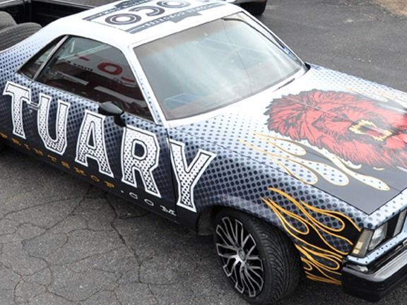 Custom black-and-white race car with “TUARY” lettering and red lion graphic on the hood