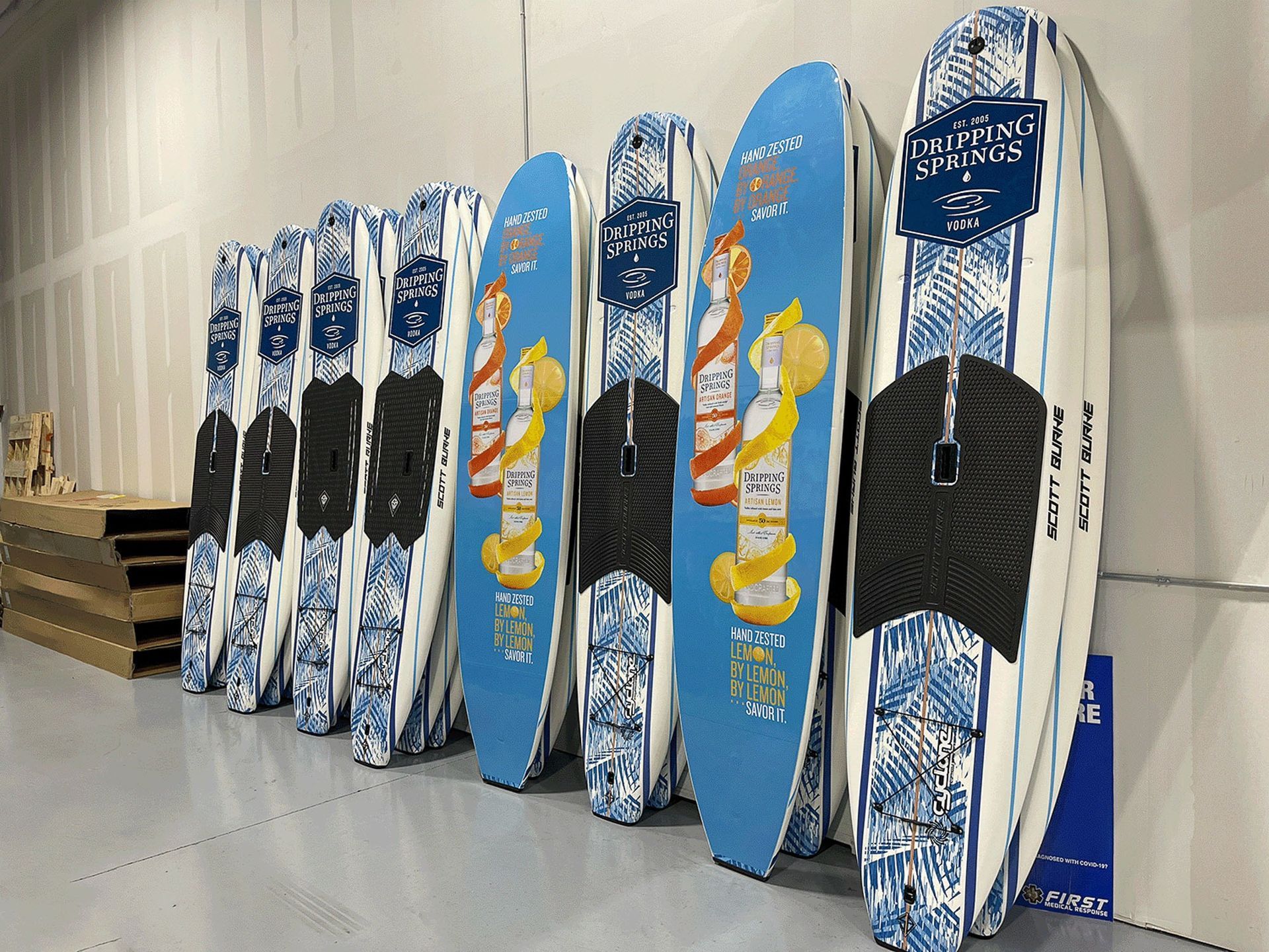 Snowboards lined up against a wall in a shop, featuring blue and black designs.
