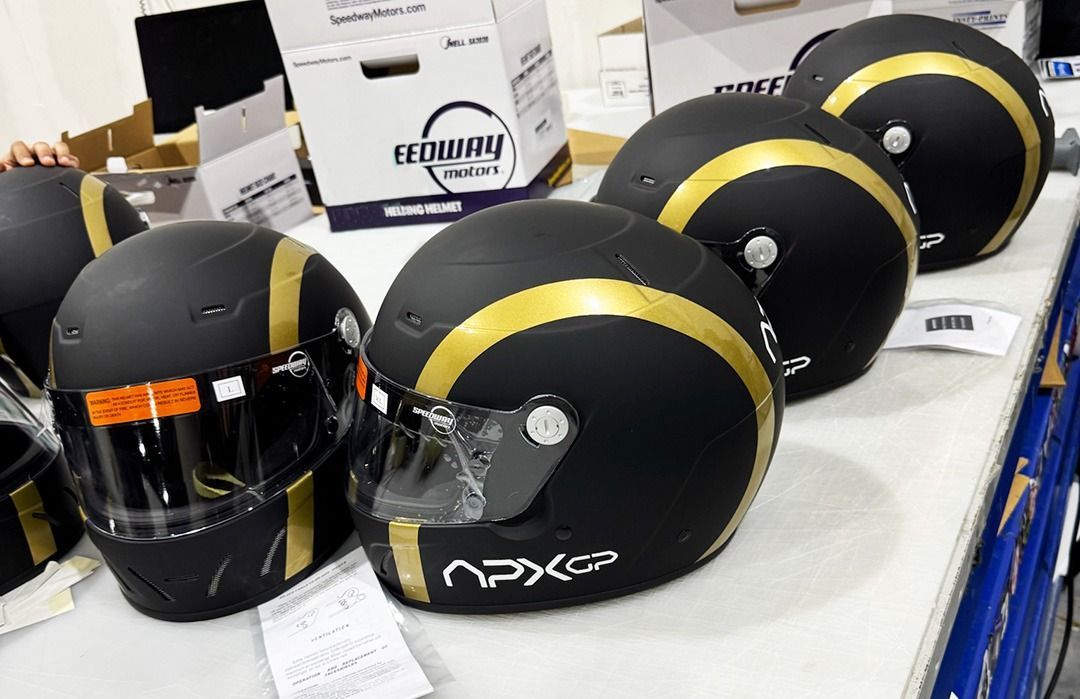 Row of black-and-yellow motorcycle helmets displayed on a table in a store