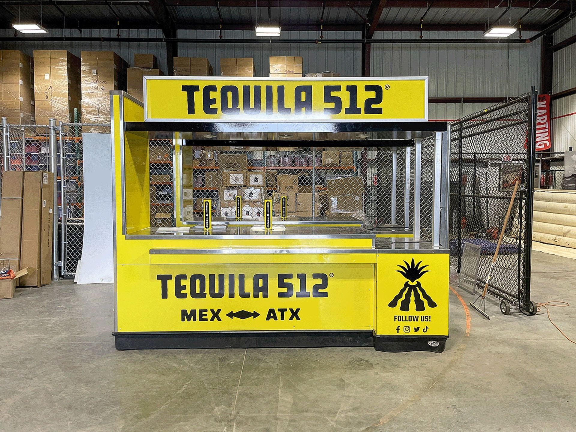 Yellow TEQUILA 512 food cart inside a warehouse, with black logo and text on the front.
