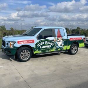Branded pickup truck for Just Right Lawns parked outdoors under a cloudy sky