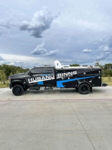Black Husqvarna service truck on a road under cloudy sky