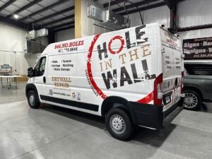 White Hole in the Wall service van parked indoors in a warehouse, with red and black company lettering.