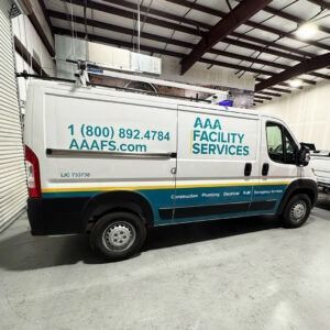 AAA Facility Services van parked indoors with teal and white logo and phone number on the side