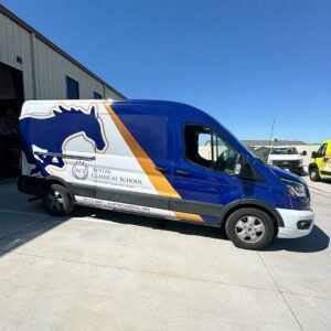 Blue and white branded van parked outside a building on a sunny day