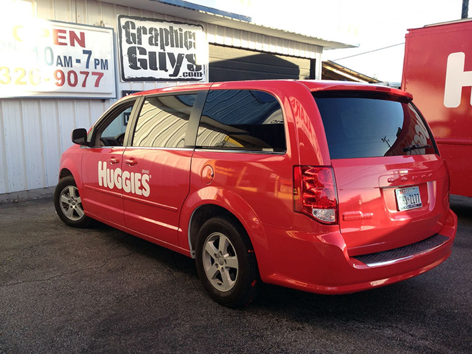 Red Hughes van parked outside a GraphiCity shop