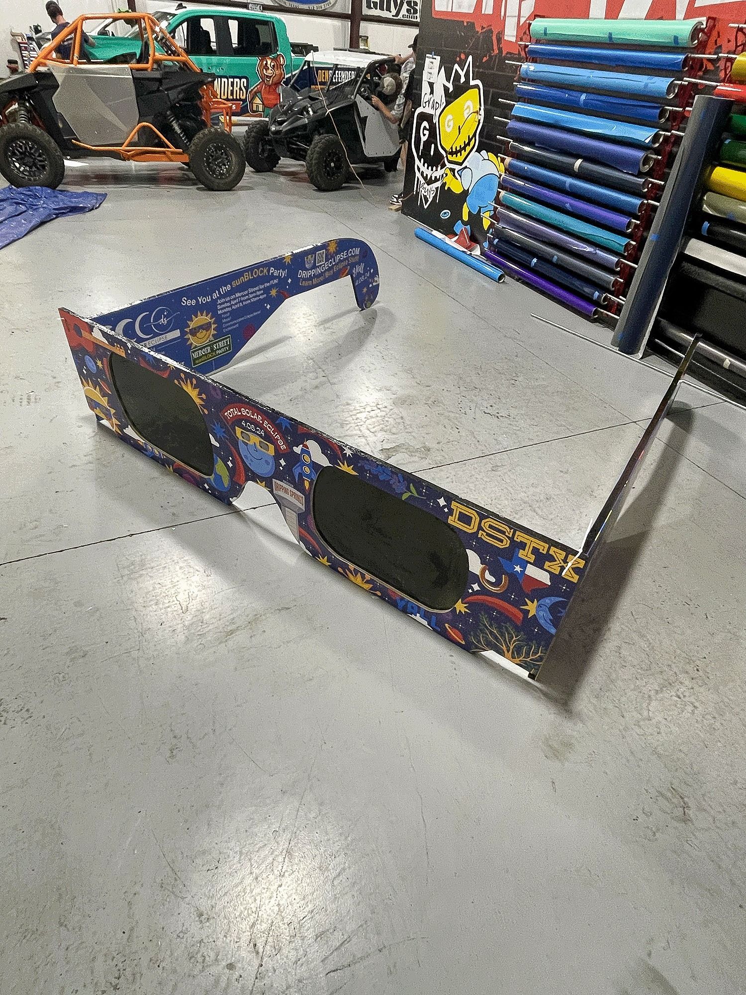 Indoor skate park with a metal rail grind box, colorful ramps, and skateboards in the background