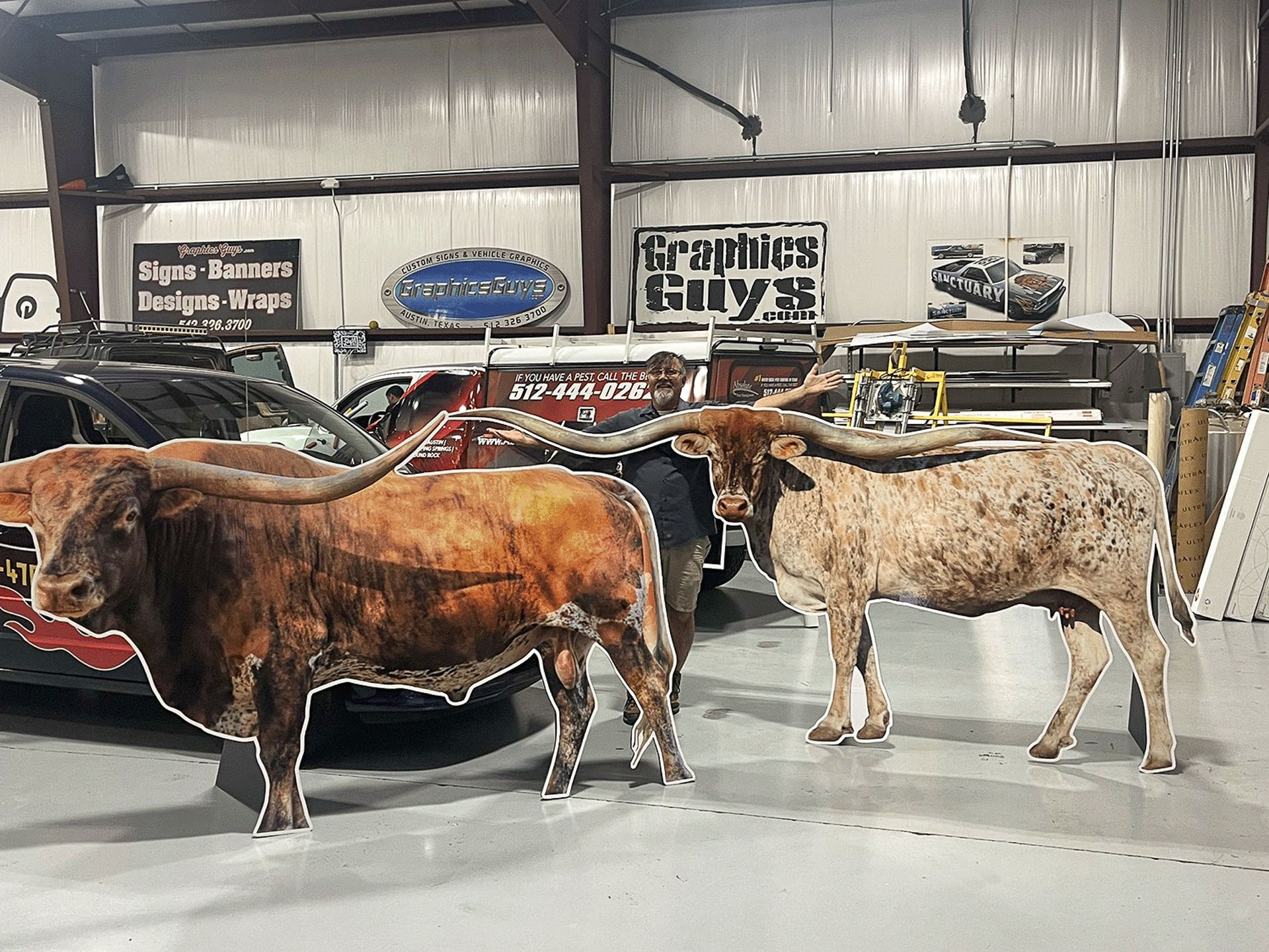 Several cattle standing indoors at a livestock barn or auction arena