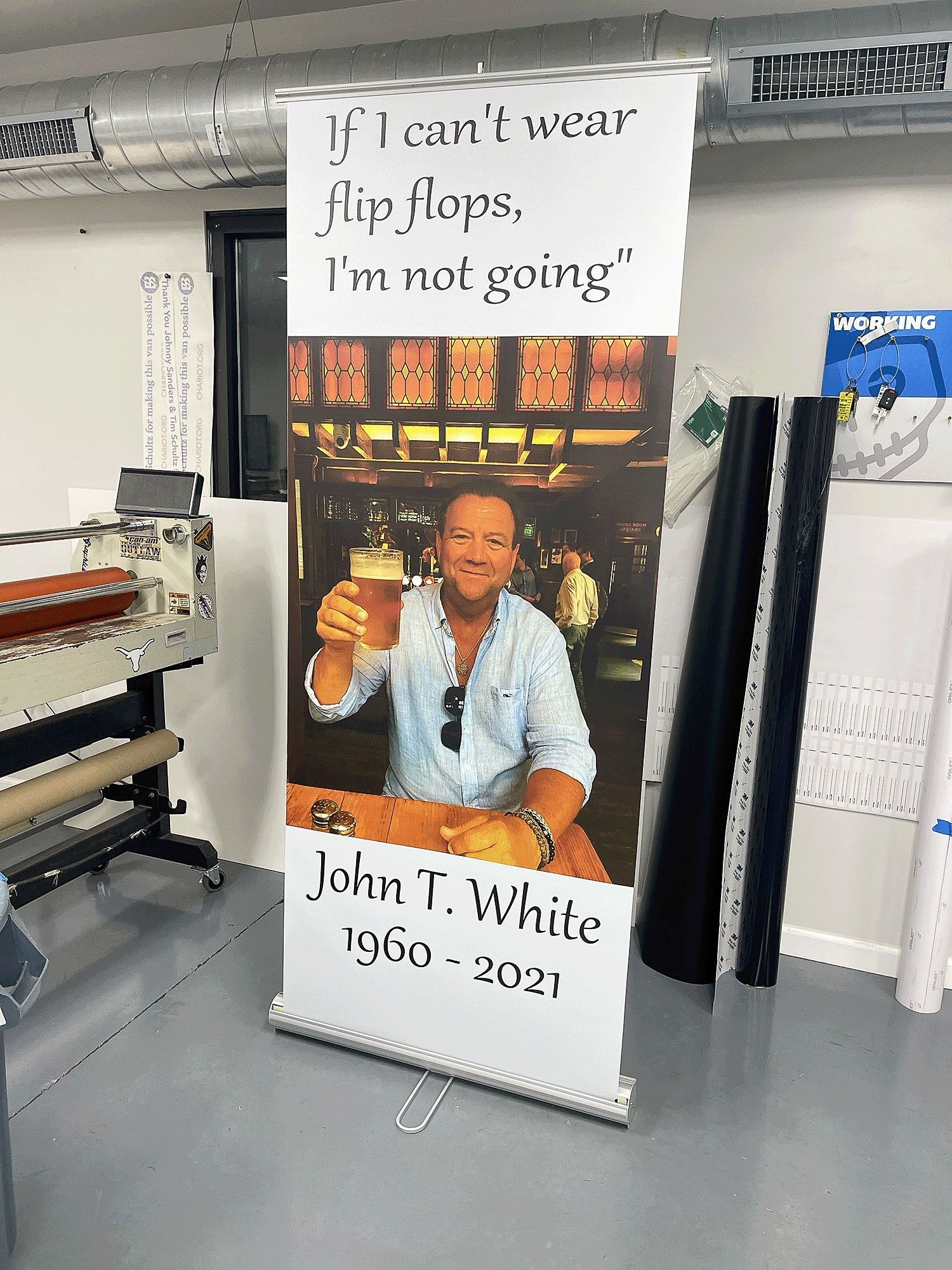 Banner with man in blue shirt and quote, “If I can’t wear flip flops, I’m not going,” by John T. White, 1950–2021
