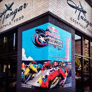 Digital billboard on a building displays Red Bull Grand Prix of Americas motorcycle race advertisement.