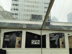 Storefront posters under a glass canopy, with a central black “SPIN” sign.