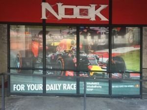 Nook storefront with a racing car display and the slogan “For Your Daily Race” across the windows