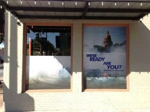 Storefront windows with a large sign reading “WE’RE READY ARE YOU?”