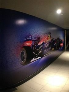 Long hallway with a large wall mural of a red Formula 1 race car on a blue wall