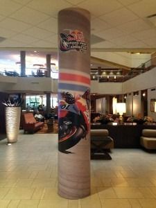 Spacious lobby with a large decorative column and lounge seating under warm lighting.